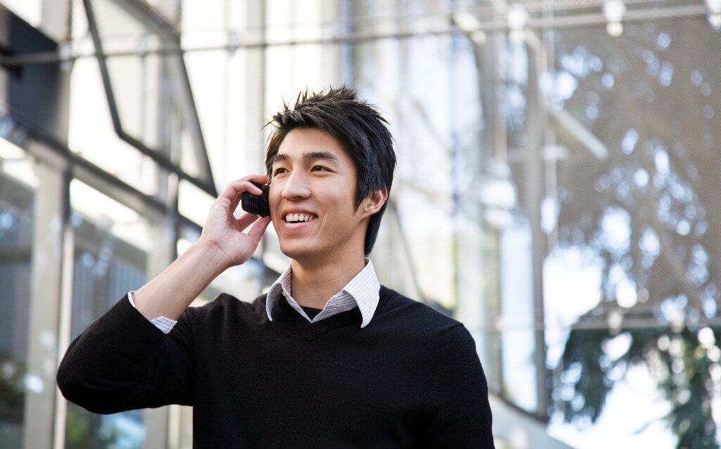 A laughing man talking on his mobile phone