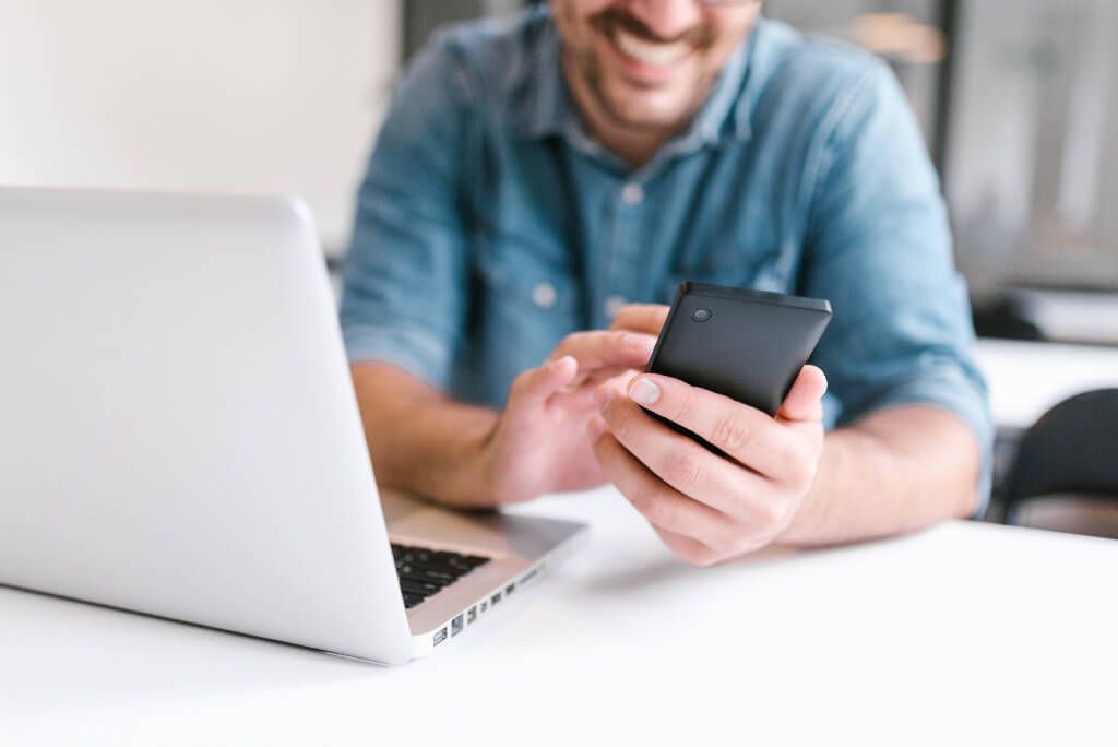 A laughing man holding his mobile phone