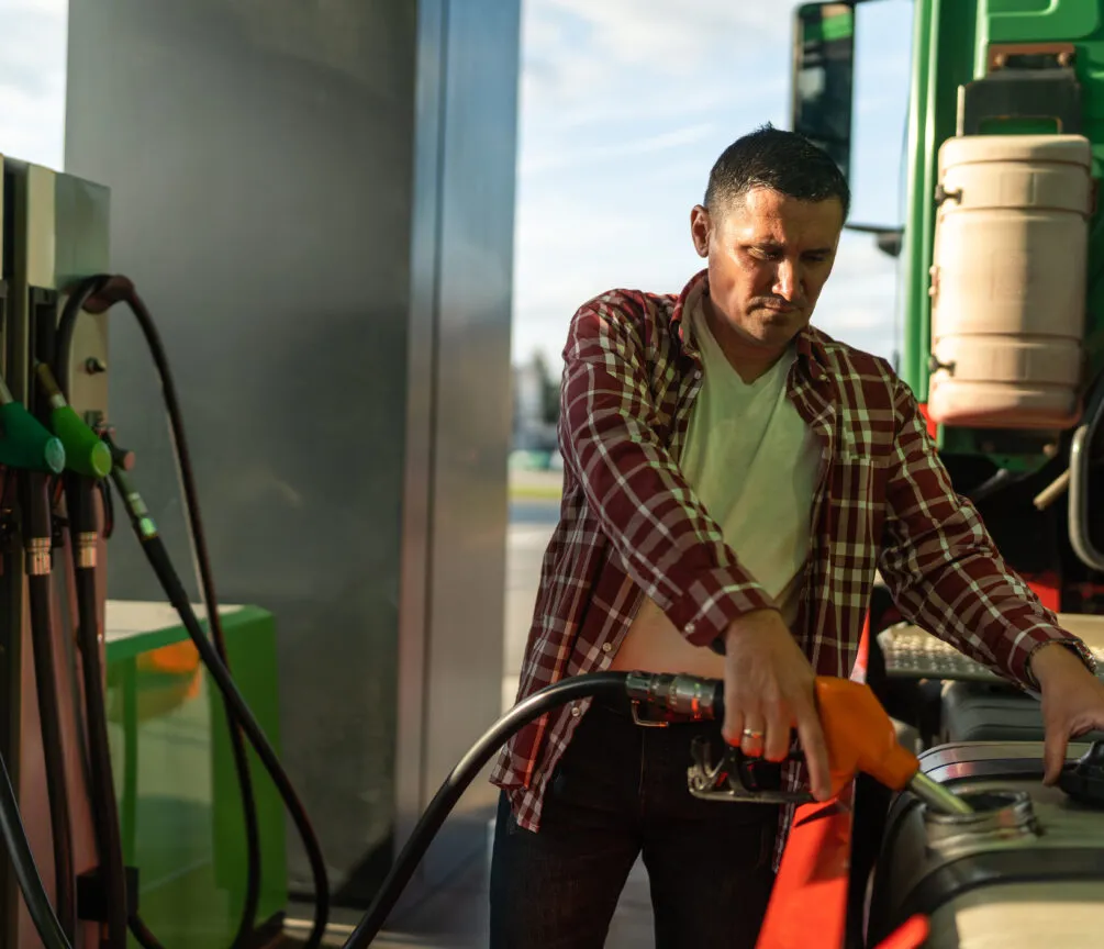 An Australian merchant serving customers at his fuel stations