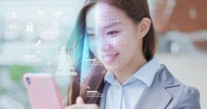 A business woman is shopping on smart phone with scanning facial recognition.