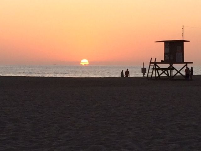 sunset on the beach with lifeguard stand