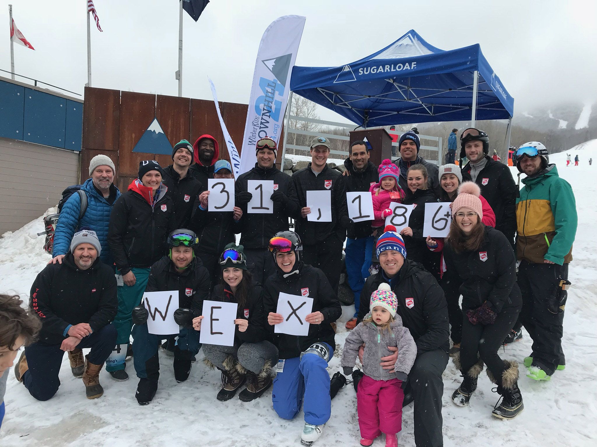 WEX participants holding signs with the amount of money WEX raised, $31,186