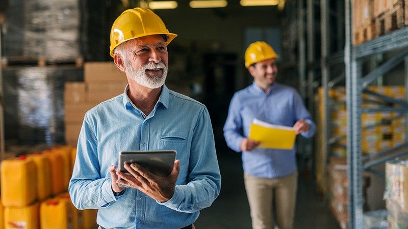 fleet manager looks through warehouse with tablet