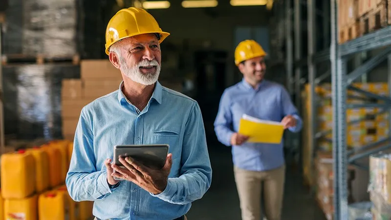 fleet manager looks through warehouse with tablet