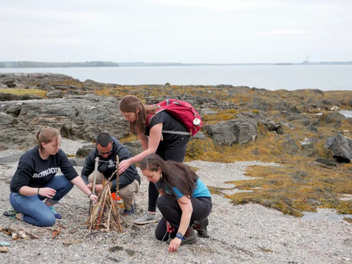 Group of interns working together to light a fire