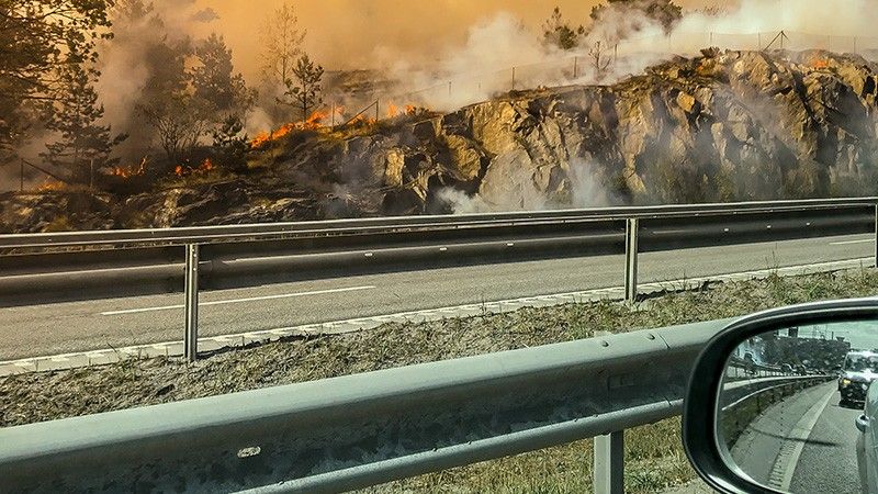 car passes fire on highway