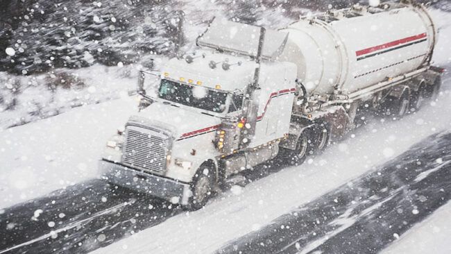 truck driving through snowy road