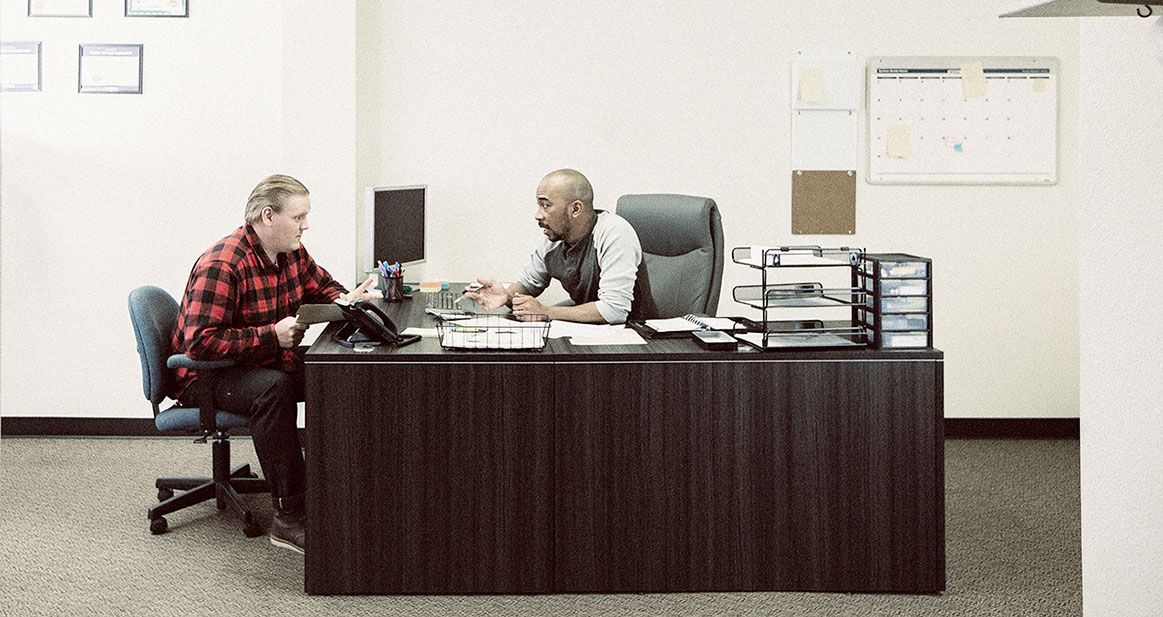 employee speaking with manager in office