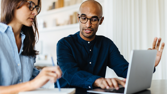 Man and woman working on a laptop.