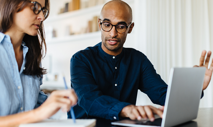 Man and woman working on a laptop.