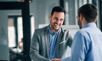 Small business owner smiling and shaking hands with someone