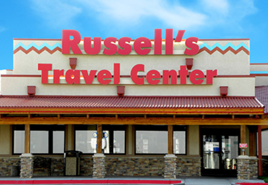 Outside view of Russell's Travel Center, with blue skies in the background.