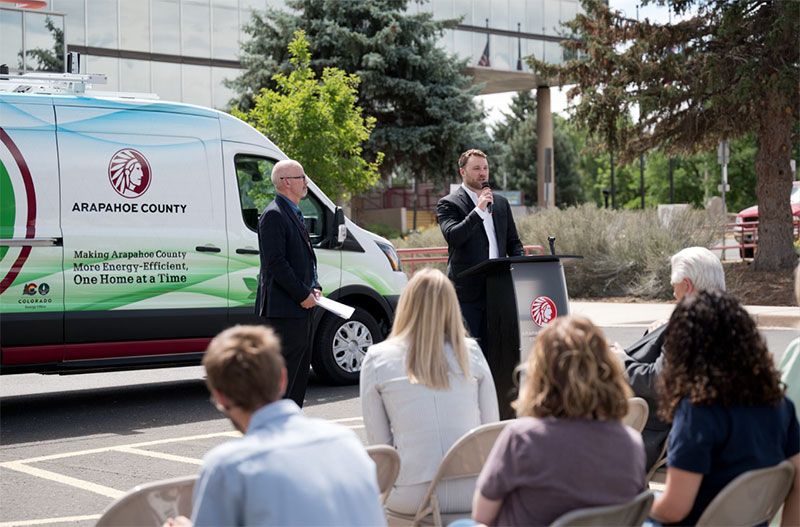 People in a crowd at a ribbon-cutting event
