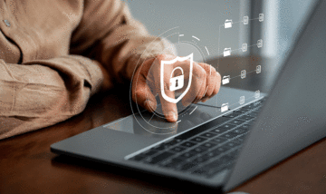 Person scrolling on laptop with a lock graphic overlay
