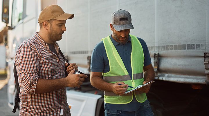 truckers talking in front of vehicle