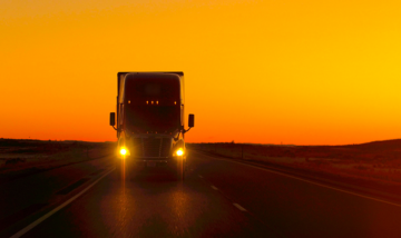 long haul truck on the road at sunset
